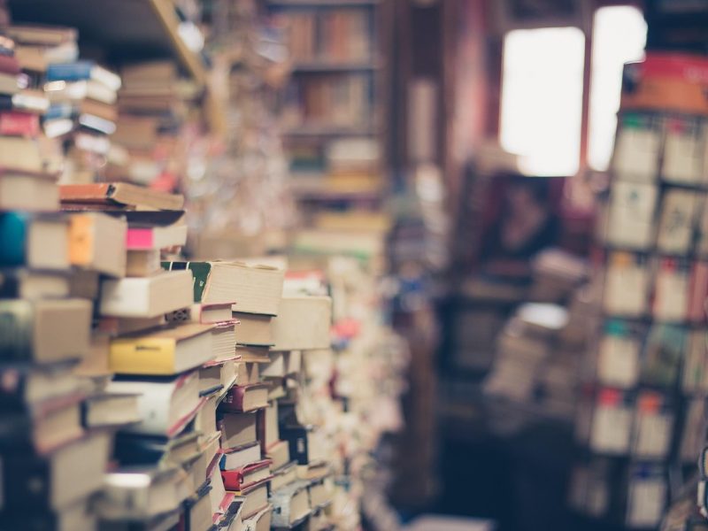 51爆料品牌简介配图，暖木色长桌上摊开一叠标注批次的索引卡，旁边搁着金色书签与放大镜，窗外光线斜入，呈现安静的信息核对氛围